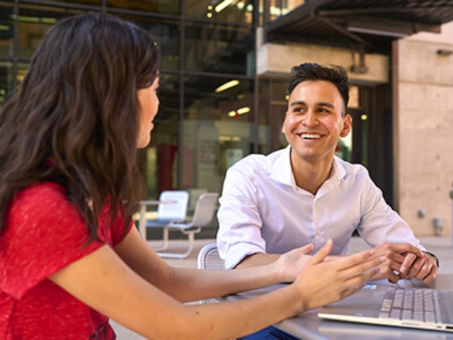 Faculty working with student on a laptop at the Thrive Center